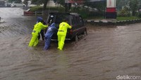 Polisi mendorong mobil yang mogok.