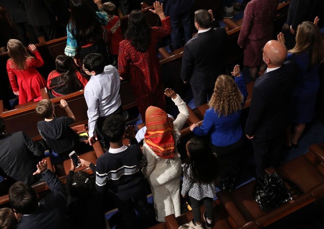 Di acara pelantikan anggota House of Representative atau DPR (Dewan Perwakilan Rakyat), Ilhan Omar tampil memakai dress berwarna putih dipadukan dengan pashmina etnik bernuansa oranye. Foto: Getty Images/Win McNamee