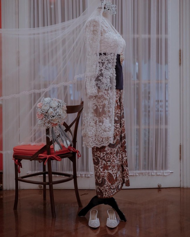 Penampilan pengantin tetap modern dengan angkin atau stagen berwarna hitam dan bros besar bergambar mawar di tengahnya. Foto: Dok. Aldi Photography