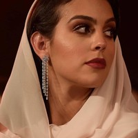 Gaun yang ia pilih memiliki potongan cape dengan belahan dada rendah. Anting panjang juga tampak cantik menggantung di dalam helaian scarf yang menutupi sebagian rambutnya. Foto: Instagram