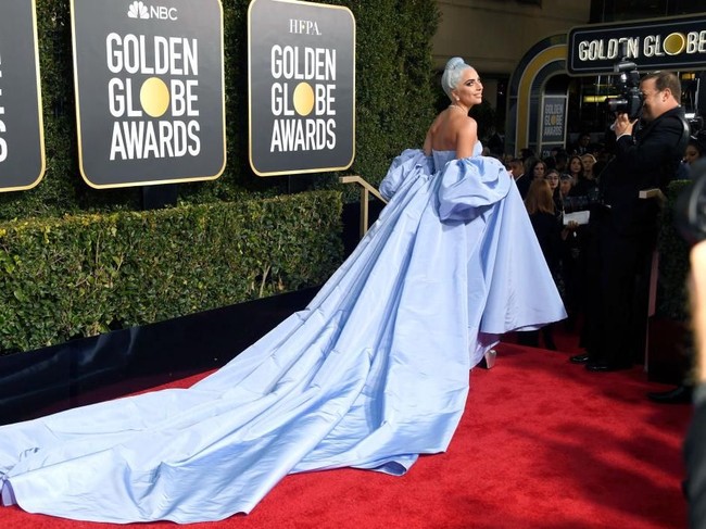 Gaun Lady Gaga hadir dengan ekor panjang yang menyapu lantai sehingga menciptakan kesan dramatis. Belum lagi lengan bervolumenya. Stunning! (Foto: Getty Images)