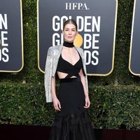 Aktris Rosamund Pike memancarkan aura seksinya dengan gaun berdetail cut-out yang dipadu cropped blazzer berkilauan. (Foto: Getty Images)