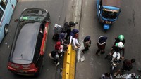 Warga melompati separator di bawah Skybridge Tanah Abang.