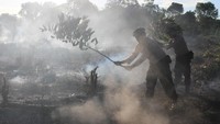 Personel Kepolisian Polres Aceh Barat memadamkan api yang membakar lahan gambut dengan cara manual di Kawasan Desa Seuneubok, Kecamatan Johan Pahlawan, Aceh Barat, Aceh, Minggu (6/1/2019). ANTARA FOTO/Syifa Yulinnas.