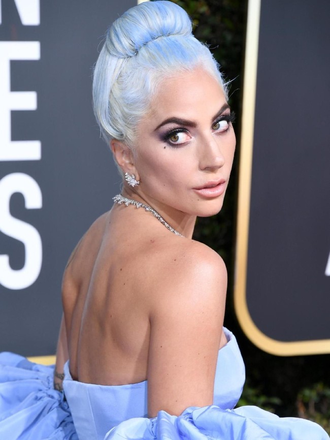 Untuk gaya rambut, penyanyi yang berjuluk Mother Monster ini memilih up-do dengan warna silver yang diberi aksen biru seperti warna gaunnya.  (Foto: Getty Images)