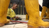 Petugas juga menggunakan las untuk memotong tiang yang tertancap.