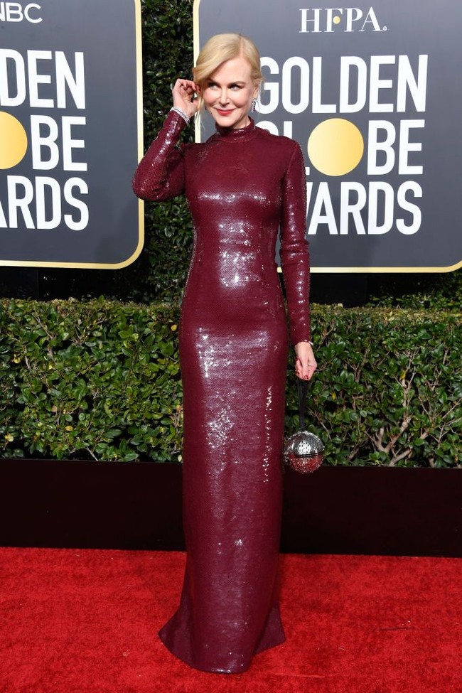 Gaun merah marun berkilauan dari Michael Kors menjadi andalan Nicole Kidman. Ia lalu memaksimalkan gayanya dengan clutch silver berbentuk bola dari Moynat. (Foto: Getty Images)
