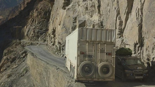 Para pengendara Pamir Highway sering dihadapkan dengan tikungan tajam yang sempit dan tebing terjal. Ban dan tebing, beda jaraknya tipis (Dave Stamboulis/BBC Travel)