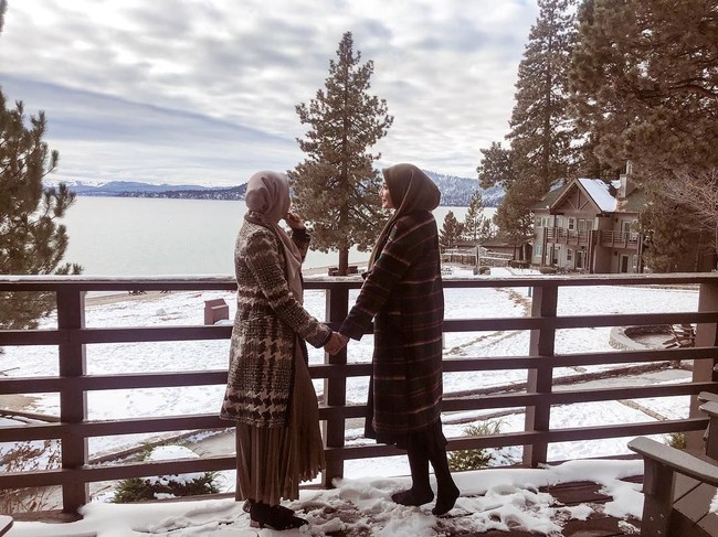 Berlibur saat musim dingin, keduanya harus memakai double layer. Entah disengaja atau tidak, keduanya memilih outerwear senada. Seperti long coat bermotif yang mereka pakai saat mengunjungi Danau Tahoe ini. Foto: Instagram/Zaskia Sungkar