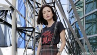 Artika tampil dengan kaus hitam dan celana bermotif kotak-kotak.