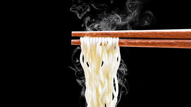 Instant noodle and spicy seasoning in white bowl with chopstick