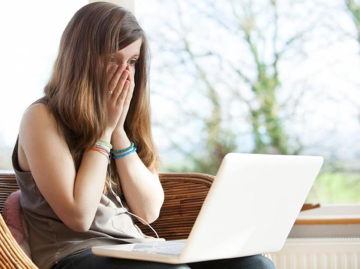 Shocked and surprised boy on the internet with laptop computer concept for amazement, astonishment, making a mistake, stunned and speechless or seeing something he shouldnt see