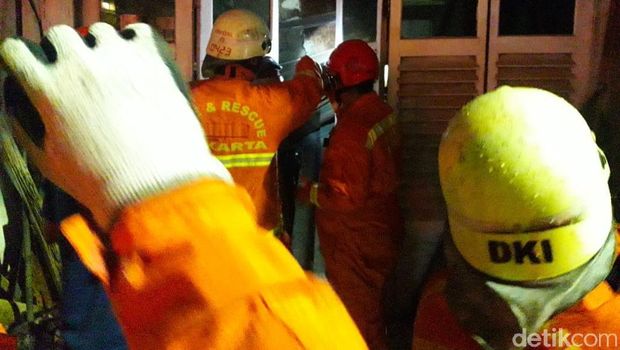 Petugas menyelamatkan penghuni rumah yang terjebak
