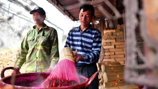Setelah itu stik-stik bambu ini dicelupkan ke gentong yang berisi pewarna merah. Kemudian stik dijemur. (Manan Vatsyayana/AFP) Setelah itu stik-stik bambu ini dicelupkan ke gentong yang berisi pewarna merah. Kemudian stik dijemur. (Manan Vatsyayana/AFP)