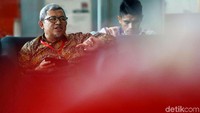 Aher nampak santai saat duduk di lobi gedung KPK menunggu panggilan penyidik.
