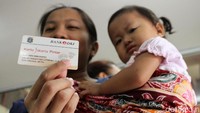 Seorang warga menunjukkan Kartu Jakarta Pintar (KJP) yang akan digunakan untuk membeli sembako murah di salah satu toko di Pasar Grogol, Rabu (9/1/2019).