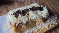 Roti bakar buatan Momomilk Barn terkenal enak. Potonganya lebih tebal dengan presentasi cantik di atas talenan kayu. Roti Bakar Momo diisi pipilan jagung manis dan susu kental manis. Pelengkapnya taburan keju dan meisjes. Foto: dok. detikFood