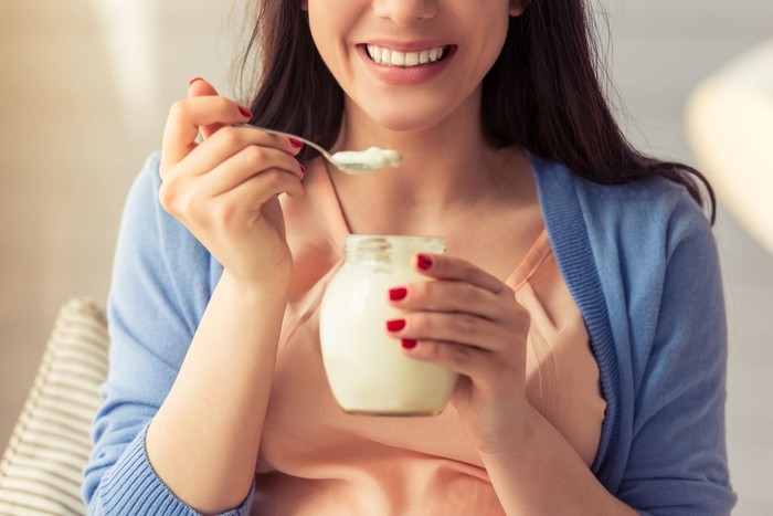 Young woman eating yogurt, closeup