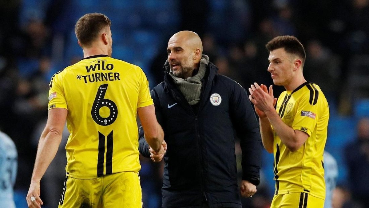 Pep Guardiola menyalami para pemain Burton Albion di akhir laga leg pertama semifinal Piala Liga Inggris (Phil Noble/Reuters)