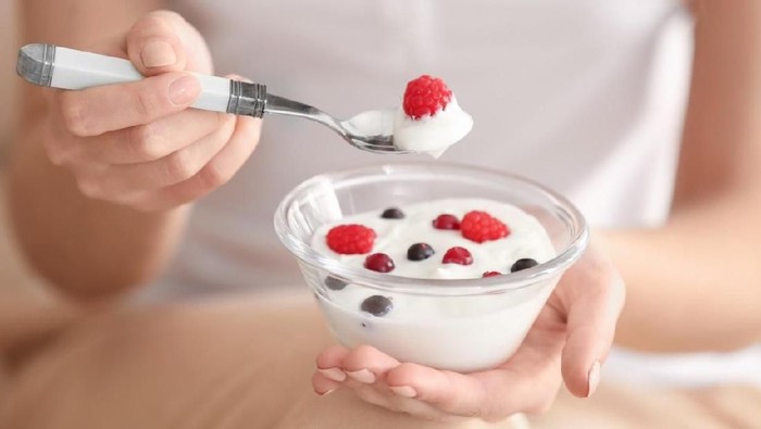 Young woman eating yogurt, closeup