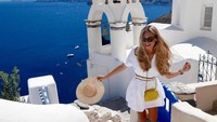 Senyum semringahnya saat menikmati keindahan Santorini, Yunani. (diana_yevdokimova/Instagram)