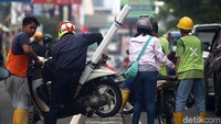 Warga membantu pengendara berpindah jalur demi menghindari razia.