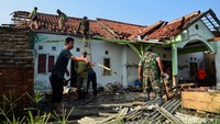 Prajurit TNI ikut memberishkan puing-puing sisa puting beliung dari rumah warga.