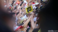Massa membawa bendera kecil bertuliskan We are alumni Jokowi