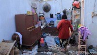 Warga berusaha merapi barang-barang di dapur miliknya yang kini terbuka tidak beratap.