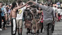 Beberapa peserta aksi menampilkan tarian khas Papua di acara car free day, Bundaran HI, Jakarta, Minggu (13/1/2019).