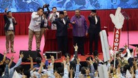 SBY naik ke panggung acara dan melakukan salam dua jari bersama Prabowo dan Sandiaga Uno.