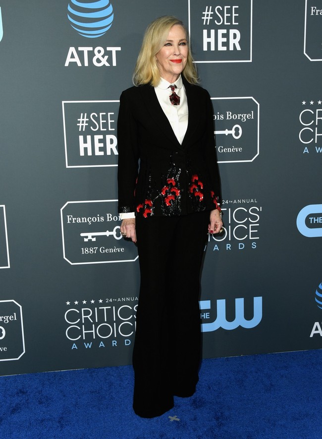 Aktris senior Catherine OHara menebar pesonanya dengan blazer berhiaskan bordir berikut kemeja yang dhiasi kalung di bagian kerah. (Foto: Getty Images)