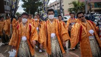 Para laki-laki juga mengenakan baju tradisional Jepang saat menghadiri perayaan upacara kedewasaan. Pool/Carl Court/Getty Images.