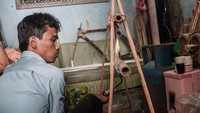 Tahap pertama adalah memilih batang bambu yang akan dipakai dan memanaskannya. (Foto: Putu Sayoga/Getty Images)