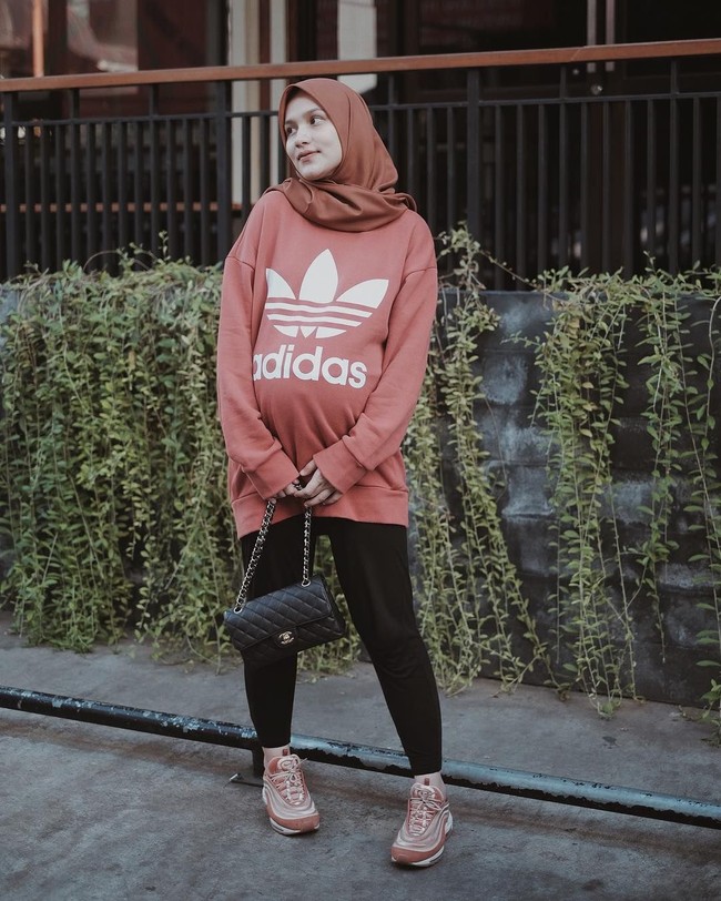 Dwi juga memilih busana kasual seperti oversized sweater dari Adidas ini. Warna peach yang ia pilih tetap memberikan kesan feminin dan cocok untukmu yang tidak ingin tampil terlalu sporty. Foto: Instagram/Dwihandaanda