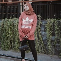 Dwi juga memilih busana kasual seperti oversized sweater dari Adidas ini. Warna peach yang ia pilih tetap memberikan kesan feminin dan cocok untukmu yang tidak ingin tampil terlalu sporty. Foto: Instagram/Dwihandaanda