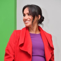 Coat Sentaler itu tampak membungkus dress ungu yang warnanya tak kalah mencolok. Tampilan warna yang saling bertabrakan (color blocking) itu sukses menjadikan Meghan sebagai pusat atensi. (Foto: Getty Images)