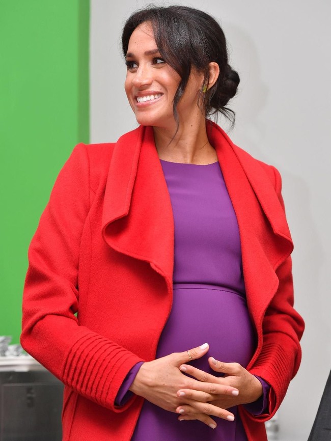 Coat Sentaler itu tampak membungkus dress ungu yang warnanya tak kalah mencolok. Tampilan warna yang saling bertabrakan (color blocking) itu sukses menjadikan Meghan sebagai pusat atensi. (Foto: Getty Images)