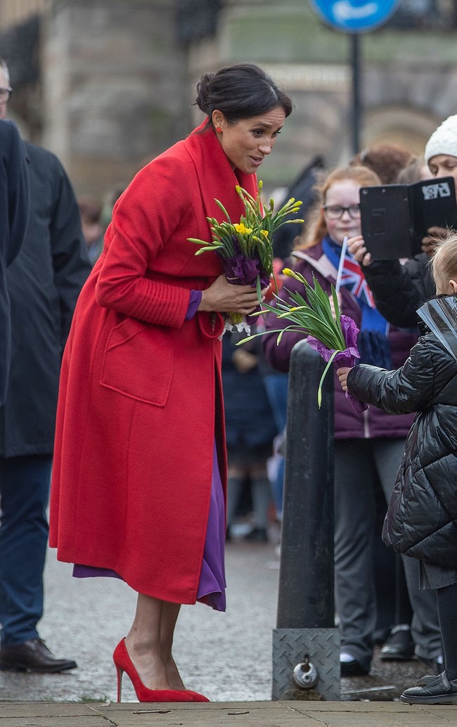 Coat merah terang keluaran sebuah label Kanada bernama Sentaler menjadi andalan perempuan yang tengah mengandung enam bulan anak pertamanya itu. Dilihat di situsnya, luaran dari seri Long Wide Collar Wrap Coat itu dijual seharga US$ 1.395 atau Rp 20 jutaan. (Foto: Getty Images)
