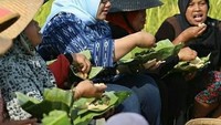 Tanpa gengsi, Mbak Yuni duduk beralas tanah dan makan dari wadah daun pisang. Ini adalah sawah padi organik di Kecamatan Sambirejo, Sragen. Foto: instagram @mbakyuni_sragen