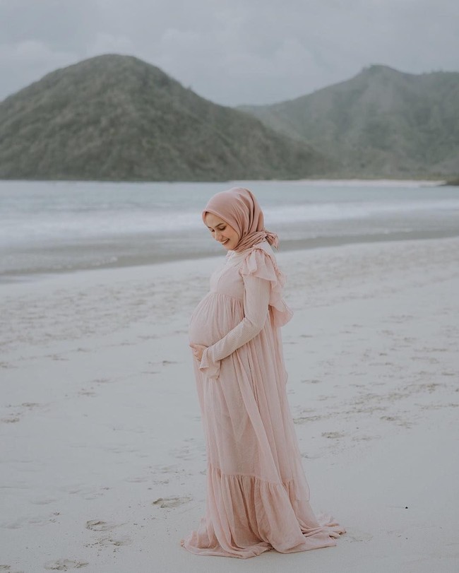 Saat melakukan maternity photoshoot, Dwi memilih busana karya Barli Asmara. Gaun berbahan lace ini terinspirasi dari kehidupan kota Paris di abad 17. Busananya terlihat romantis dan girly. Foto: Bastian Najich (Instagram @alineapict)