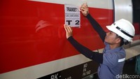 Petugas memasang poster berupa gerbong Trailer Car (T) yang sudah dilakukan proses instalasi listrik.