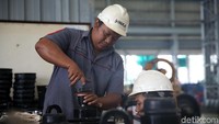 Beberapa melakukan perakitan bogie untuk dipasang.