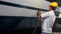 Seorang petugas  tengah membersihkan sisa kotoran pasca proses pengecatan.
