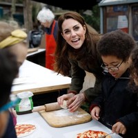 Ia sempat membuat pizza bersama para murid dari SD yang berada di sekitaran lokasi tersebut. Mendapat pertanyaan dari anak-anak bilamana Ratu Elizabeth II suka makan pizza, Kate pun menjawab, Itu pertanyaan yang bagus tapi aku tidak tahu. Nanti aku tanyakan ke Ratu, jawab Kate. (Foto: Getty Images)