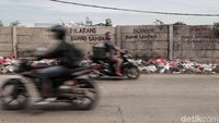 Tulisan larangan buang sampah tidak dihiraukan. Tempat tersebut tetap dijadikan untuk buang sampah.