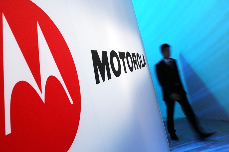 NEW YORK, NY - SEPTEMBER 05: A person walks by a Motorola sign at the launch of three new Motorola smartphones under its Razr brand that will become available for Verizon customers on September 5, 2012 in New York City. The new phones, the Droid Razr HD, the Razr M and the Razr Maxx HD, will all use Googles Android operating system. Motorola Mobility was acquired by Google in August of 2011.  (Photo by Spencer Platt/Getty Images)