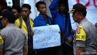 Spanduk-spanduk yang dibawa mahasiswa berisi tuntutan untuk mengadakan debat calon presiden di kampus. 