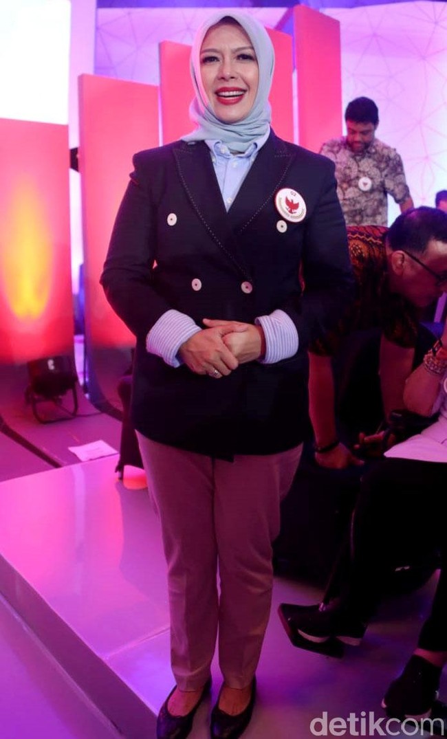 Nur Asia turut mendampingi sang suami, Sandiaga Uno, dalam debat capres dan cawapres 2019, yang digelar perdana di Hotel Bidakara, Jakarta Selatan, 17 Januari 2019. Wanita berusia 48 tahun ini memilih gaya elegan dengan power suit atau setelan jas.cNur Asia mengenakan jas model double breasted. Kancing berwarna putih yang kontras dengan jasnya yang berpalet navy membuat penampilannya lebih chic. Foto: Rengga Sancaya