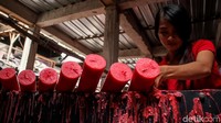 Seorang pekerja tengah menyelesaikan proses produksi lilin.